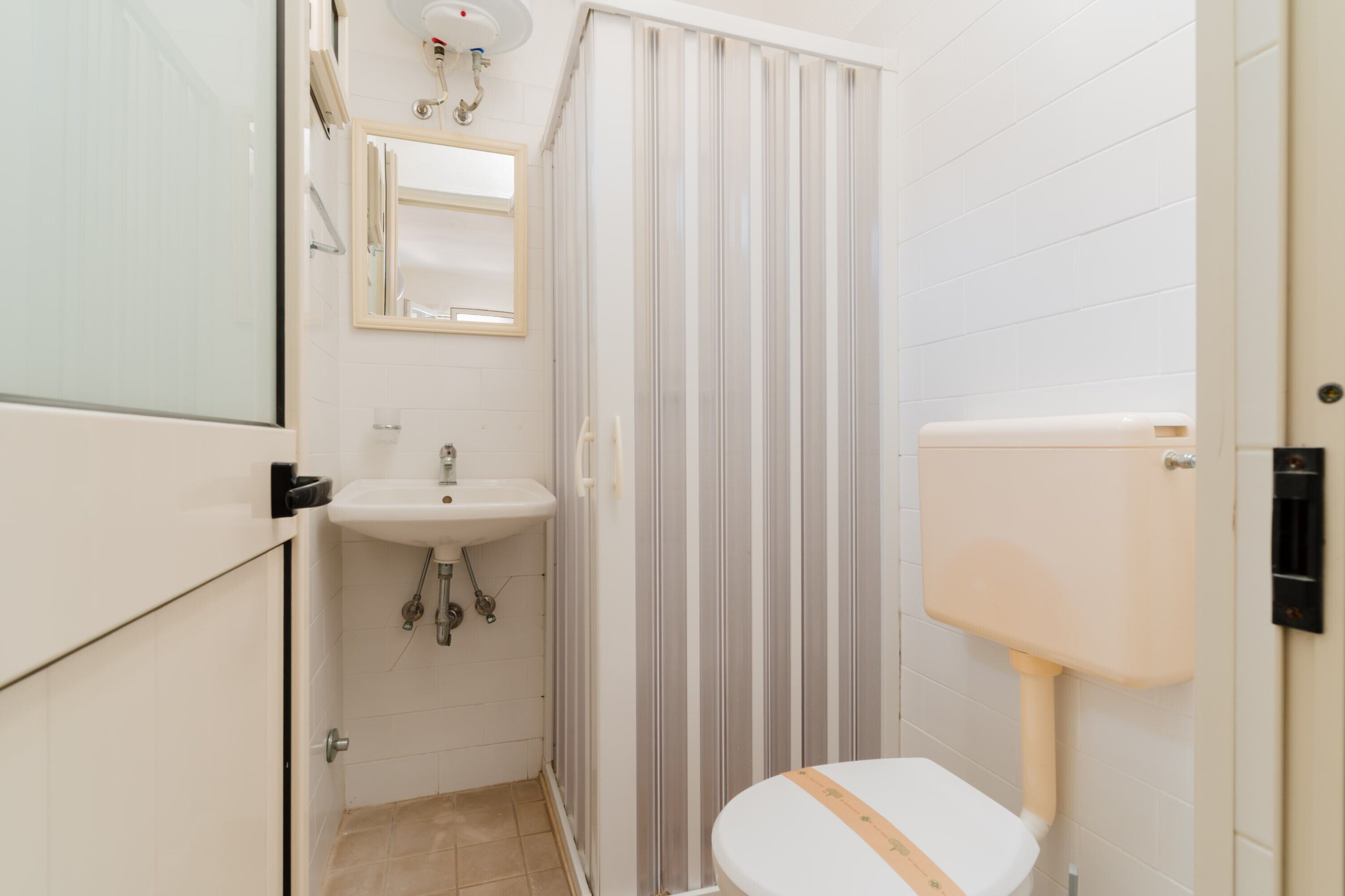 Une salle de bain équipée de toilettes, d’un lavabo et d’un rideau de douche.