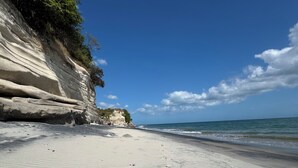 A beach with white sand and a cliff. - Ocean views, Solaria, Punta Caleo, San Carlos, Panama - one minute walk to beach (San Carlos)