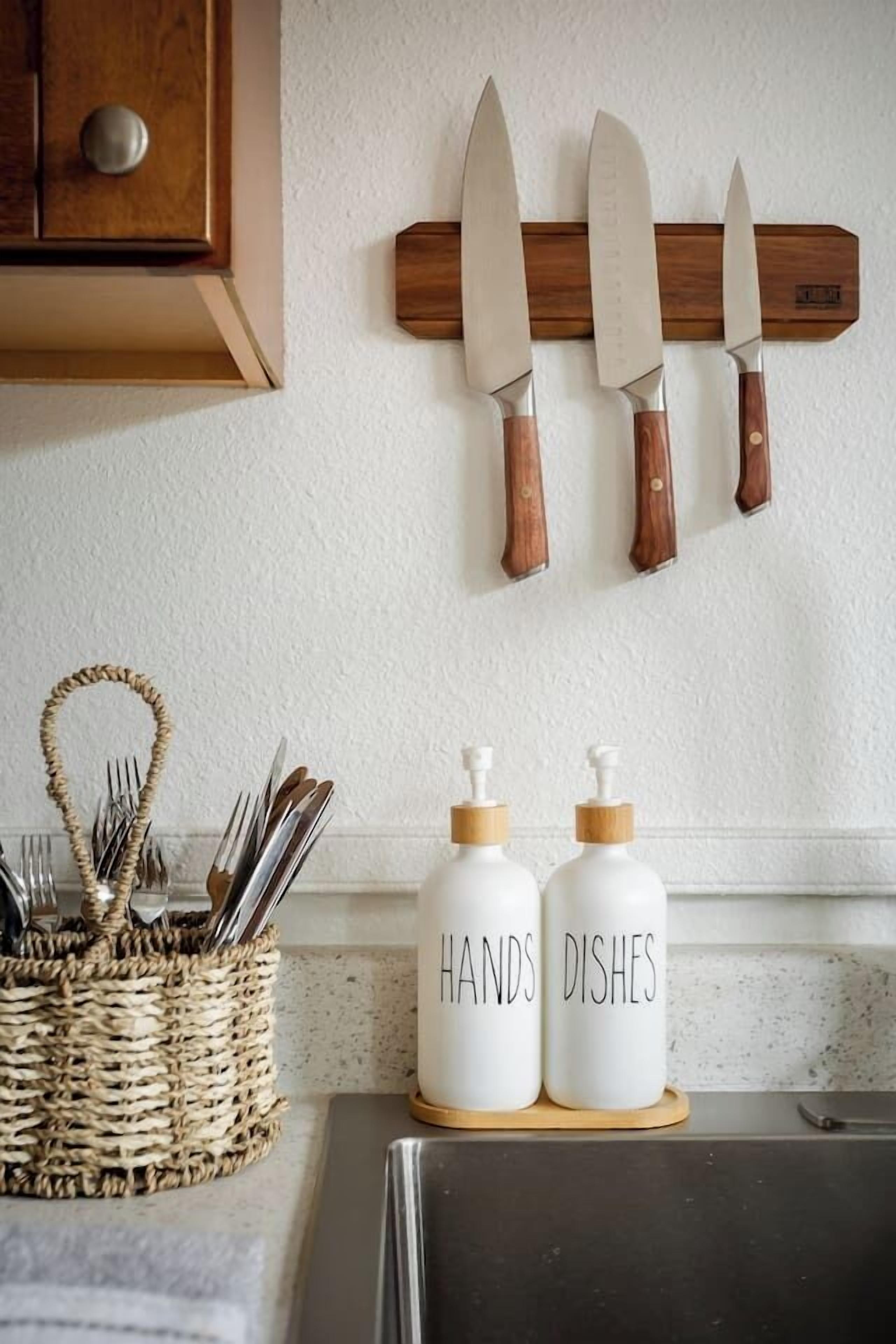 A kitchen with a wooden knife rack, a woven basket with utensils, and two white condiment dispensers labeled "HAND DISHES".