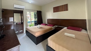 Habitación de hotel con dos camas, un escritorio, aire acondicionado y vista a zonas verdes.