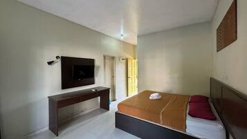 A bedroom with a bed, a desk, a TV, and a window with a view.