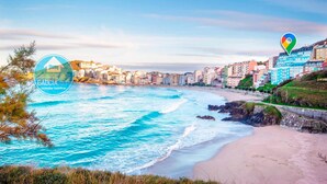 Un paisaje urbano costero con playa, edificios y cielo despejado.