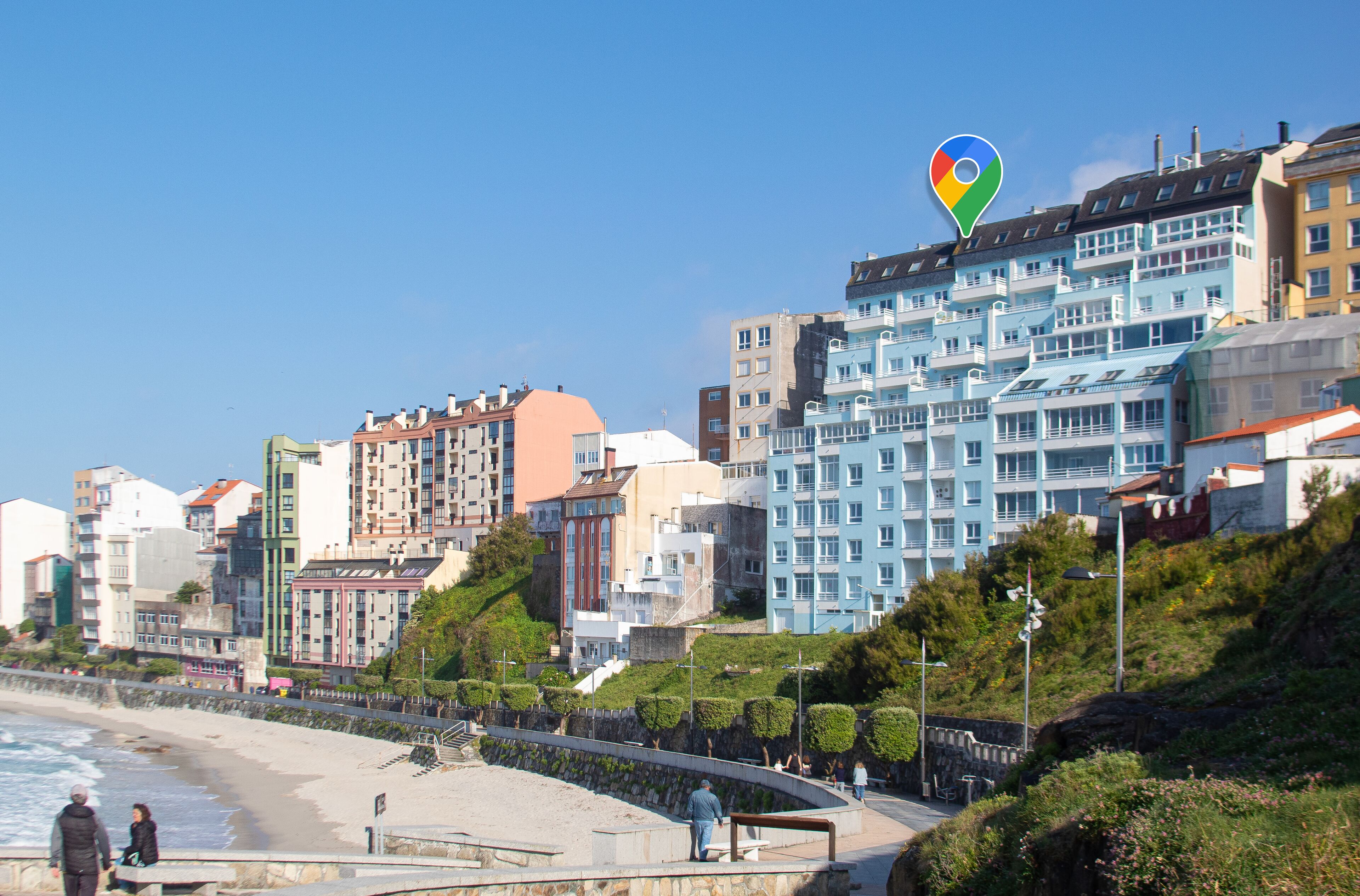 Een kuststadsgezicht met een strand, meerverdiepinggebouwen en een heldere lucht.