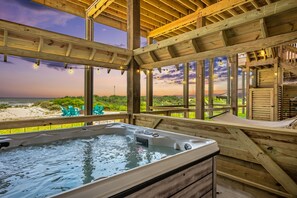 A wooden deck with a hot tub, overlooking a beach. - Luxury Beachfront Home w/ Hot Tub & Games (Crystal City)