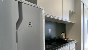 A modern kitchen with a white refrigerator, a black countertop, and light-colored cabinets. - Ycp-studio613 in S o Paulo (São Paulo)