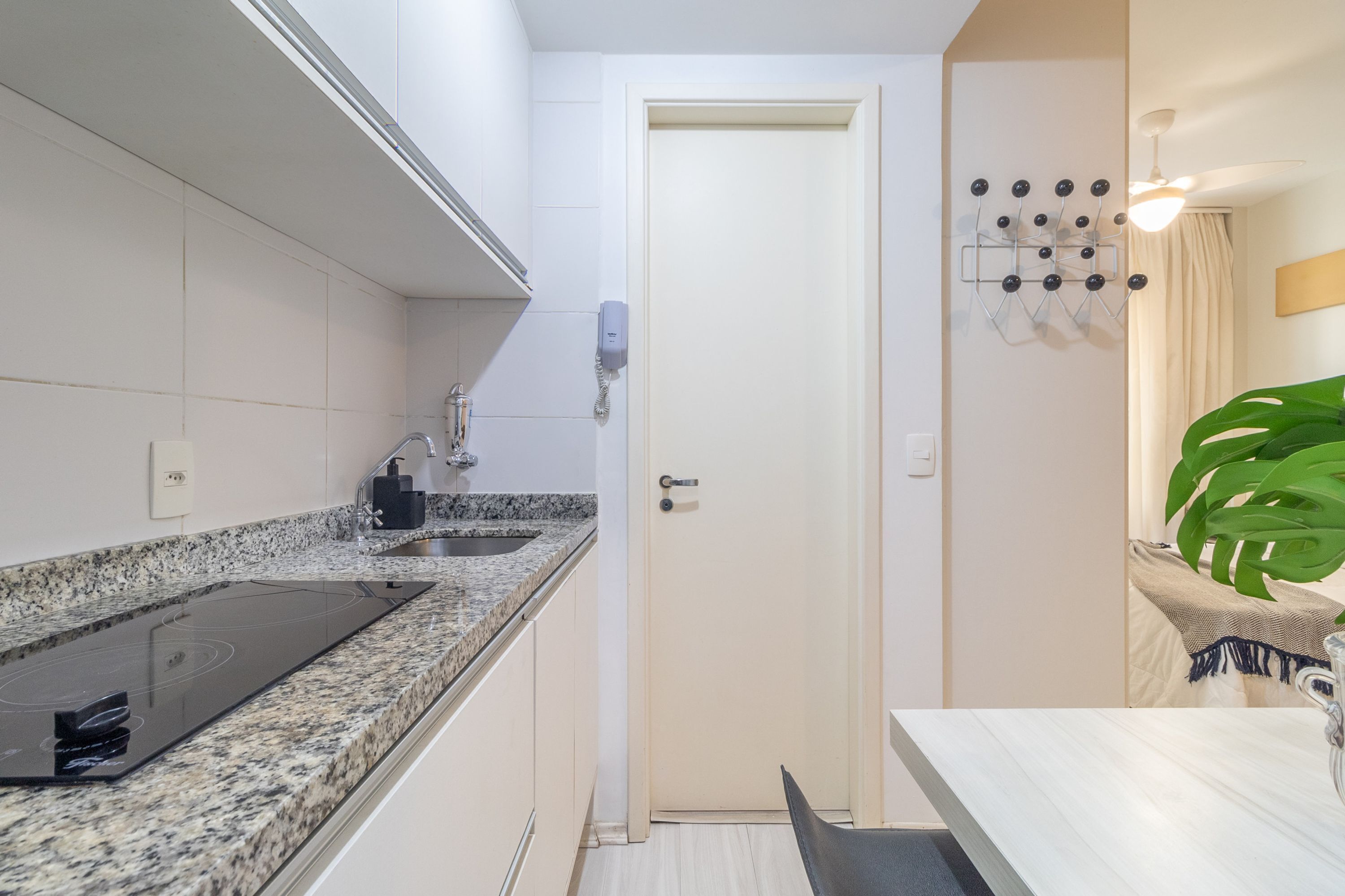 A modern kitchen with a granite countertop, built-in oven, and a small sink.