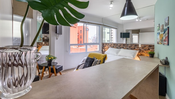 Un salon moderne avec une grande table basse en verre, un canapé confortable et une grande plante.