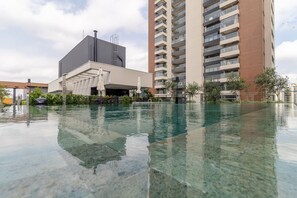 Un edificio moderno con una piscina di fronte.