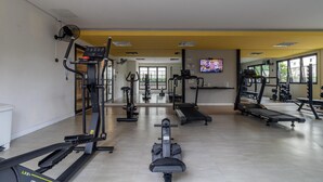 A gym with various exercise equipment, a television, and large windows. - Machado 238 Ap 137 in S o Paulo (São Paulo)