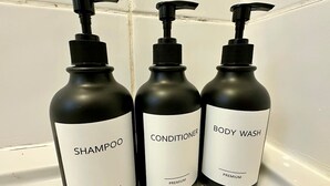 Three bottles of premium personal care products on a white surface.