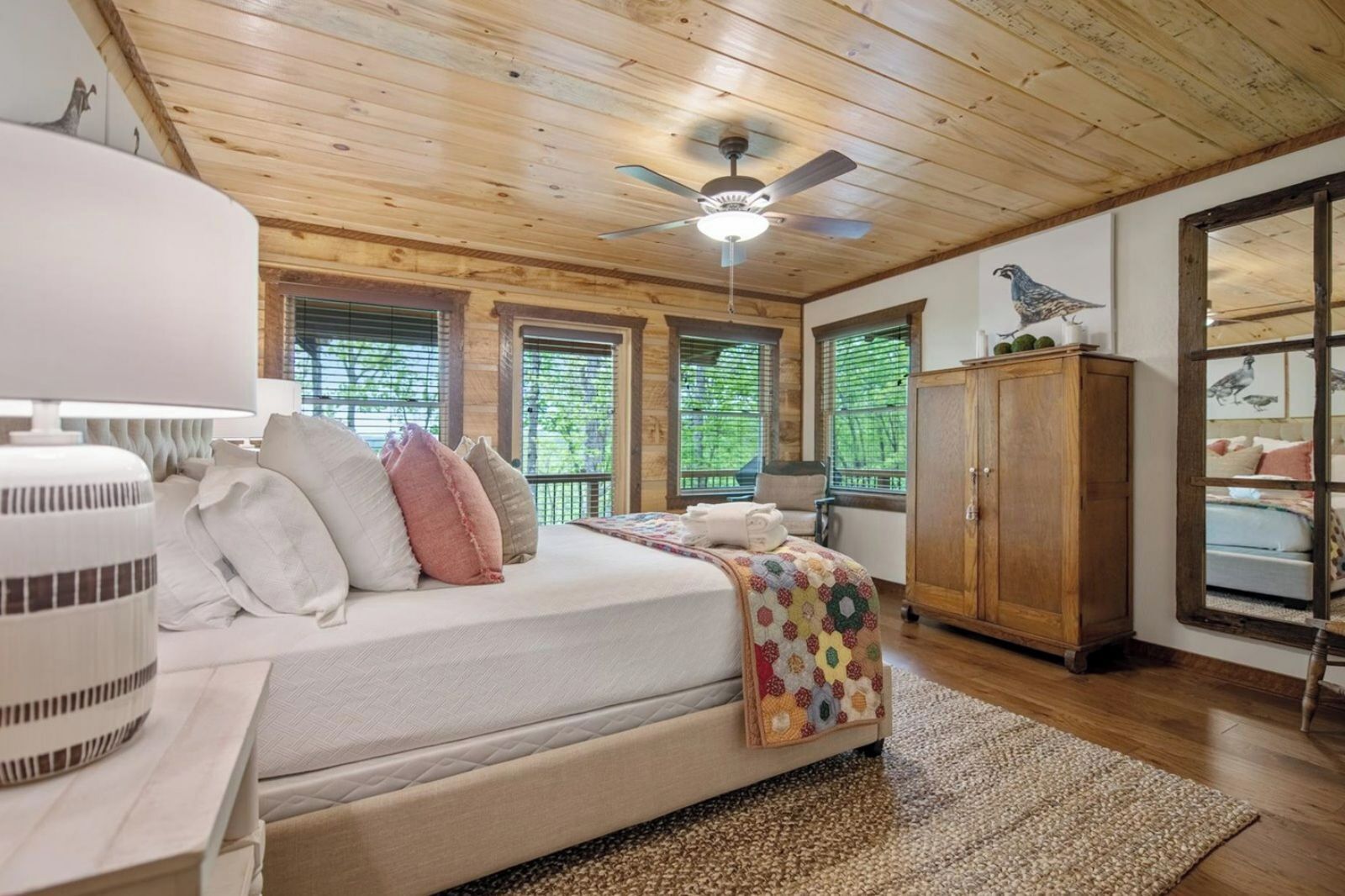 A bedroom with a bed, a wooden ceiling, a ceiling fan, and a window with blinds.