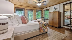 A bedroom with a bed, a wooden ceiling, a ceiling fan, and a window with blinds.