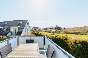 Terraza en la azotea con vistas a un barrio residencial, con casas y un parque infantil.