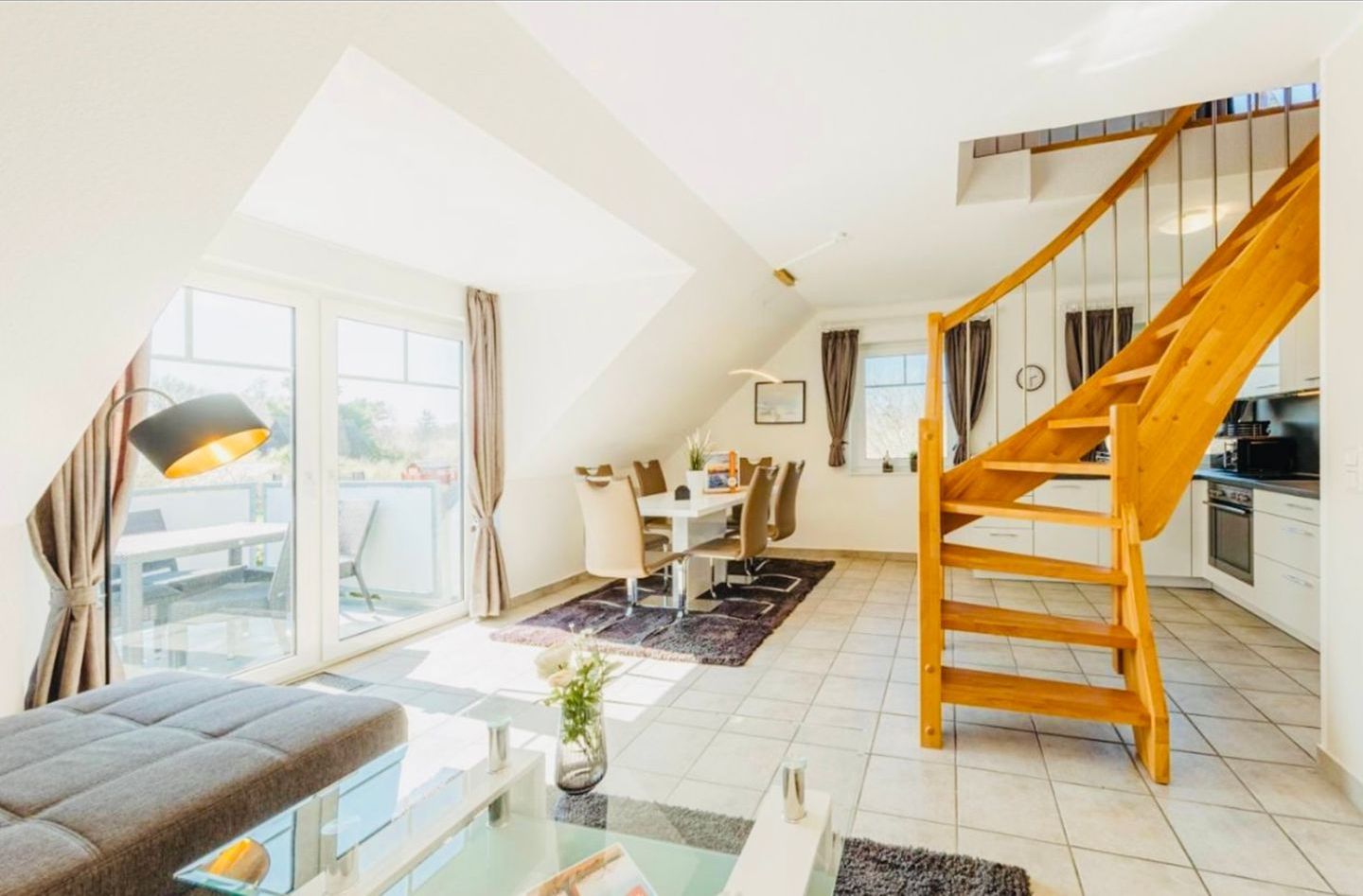 Un appartement moderne doté d’un espace de vie de style loft, d’un coin repas et d’une cuisine.