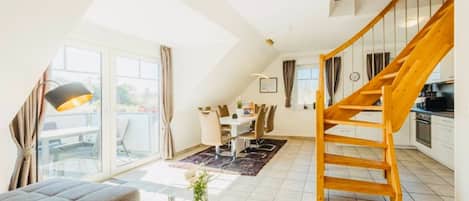En moderne lejlighed med en stue i loftstil, et spiseområde og et køkken.