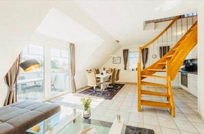 Un apartamento moderno con zona de estar tipo loft, comedor y cocina.