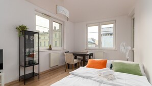 Een slaapkamer met een bed, een bureau, een stoel, een radiator en een raam.