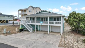 A two-story building with a balcony, a garage, and a small porch area.