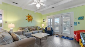 A living room with a ceiling fan, a sofa set, a coffee table, and a red armchair.