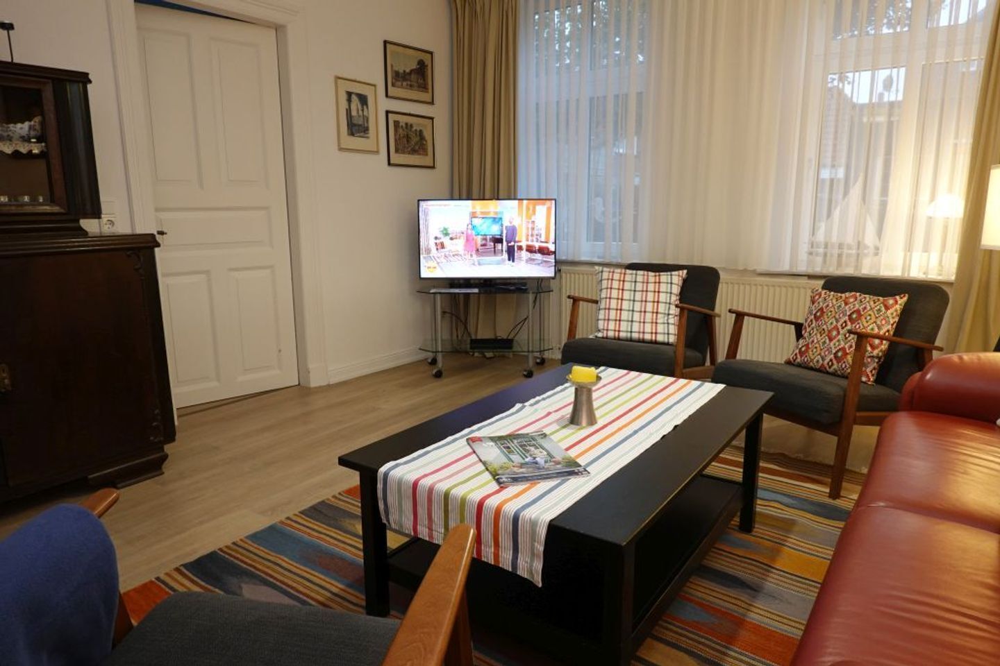 Ein Wohnzimmer mit einer Couch, einem Couchtisch, einem Fernseher und einem Schrank.