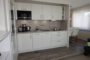 Een koelkast, een microgolfoven, een kookplaat, een vaatwasser