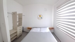 Ein Schlafzimmer mit Bett, Kleiderschrank, Nachttisch und Wanddekoration.