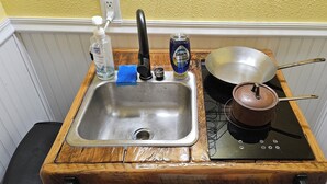 A compact kitchen with a sink, faucet, and a stove. - River Bunkie (Tivoli)