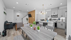 A modern kitchen with white cabinets, stainless steel appliances, and a wooden island.