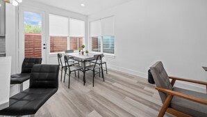 A modern dining area with a table and chairs, a bench, and a view of the outside.
