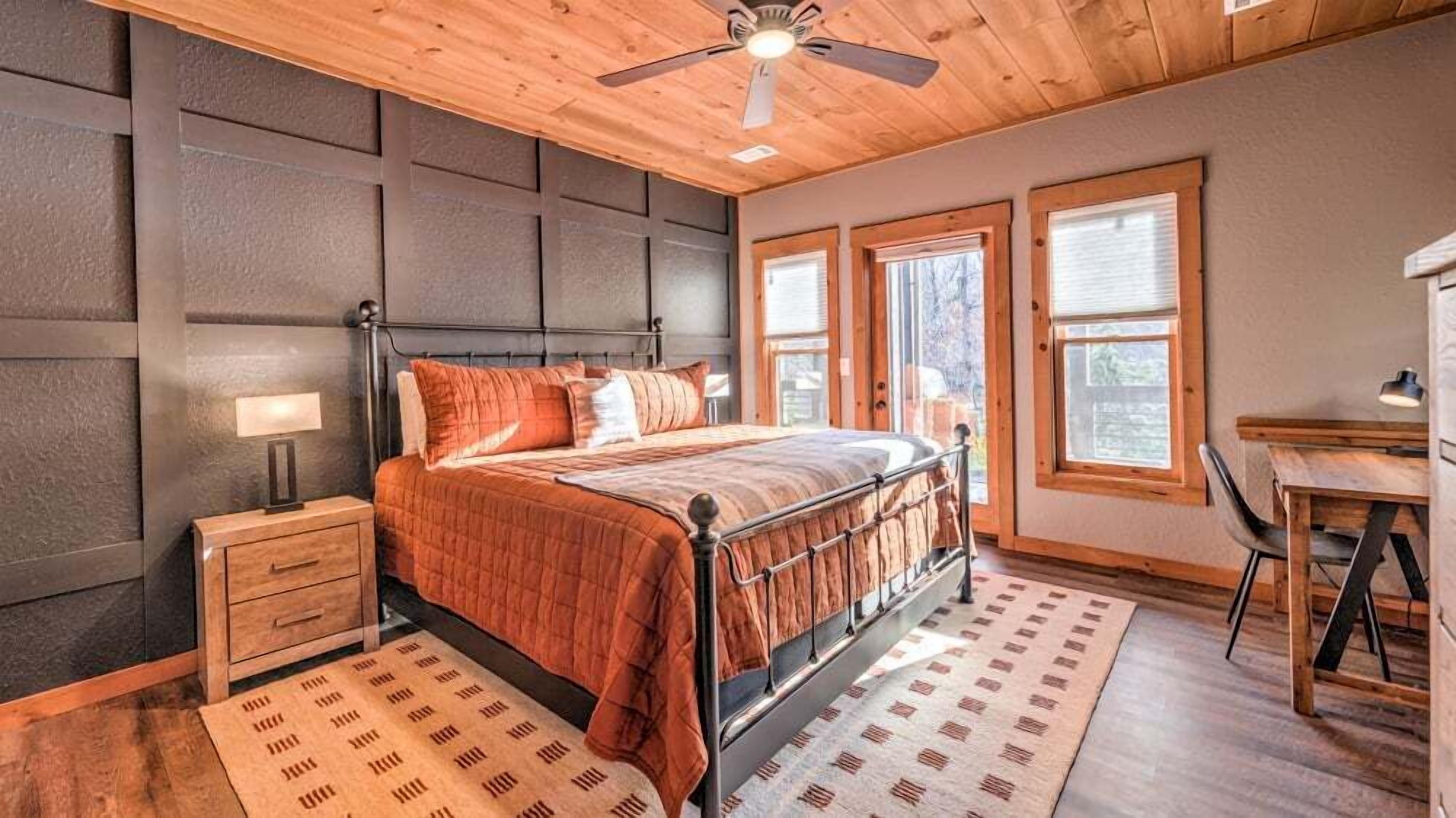 Une chambre à coucher avec un lit, des tables de chevet, un bureau et une chaise.