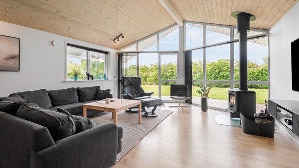 A modern living room with a large window, a fireplace, and a cozy seating area.