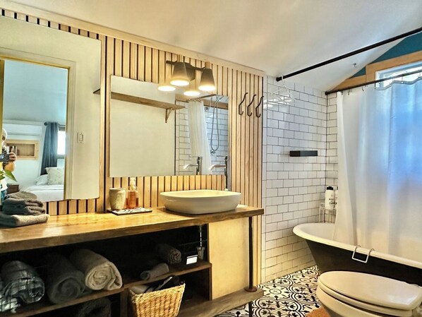Une salle de bain moderne avec un meuble-lavabo en bois, un grand miroir, un lavabo et des toilettes.