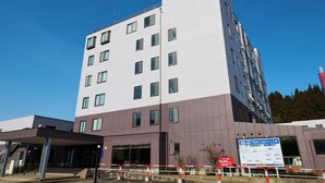 A multi-story hotel with a modern design, featuring a mix of white and purple exterior walls, large windows, and a visible entrance area with a covered walkway. - Owara View Hotel (Toyama)