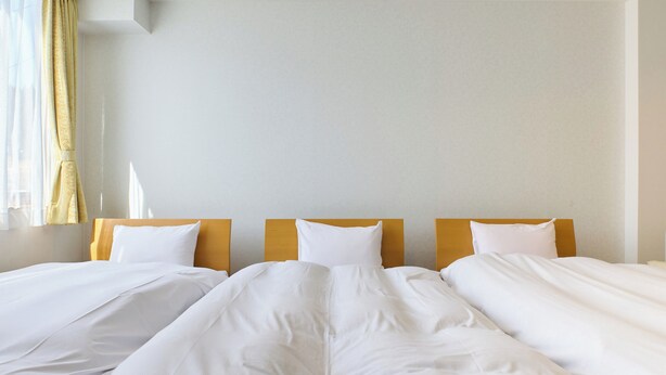 A hotel room with two single beds, each with white bedding and wooden headboards. - Owara View Hotel (Toyama)