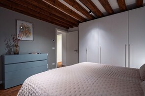 A bedroom with a large bed, a dresser, and a wardrobe.