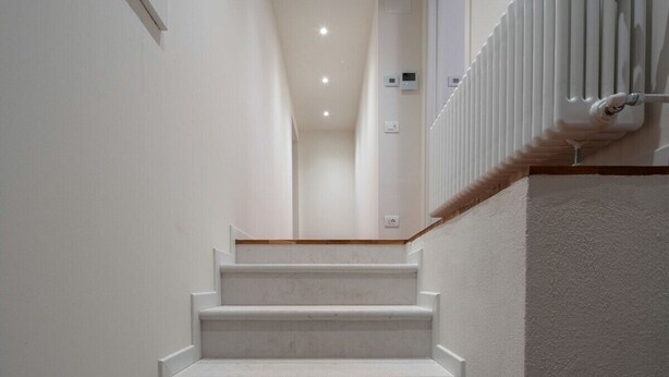 A staircase with white steps leading to a landing.