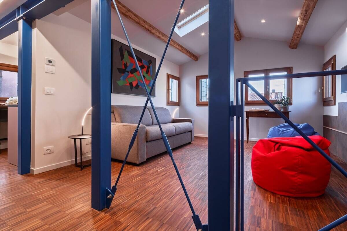 Et moderne interiør med en sofa, en saccosek og et billede på væggen.