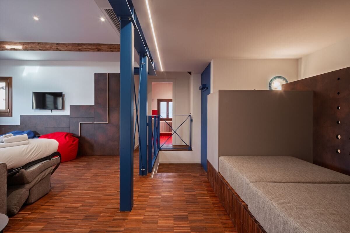 Un intérieur moderne avec un canapé, un fauteuil en forme de haricot rouge et un lit.