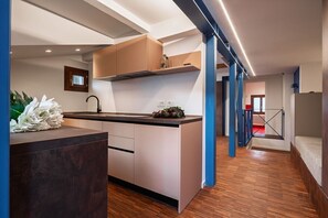 Une cuisine moderne avec un îlot central, un plancher en bois et des touches de couleur bleue.
