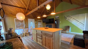 Una cocina amplia con armarios de madera, una isla central y lámparas colgantes.