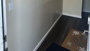 Un pasillo con un perchero, una lámpara de pared y un cuadro enmarcado.