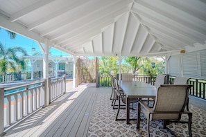 An outdoor covered patio with a pool, wooden deck, and seating area. - Private Pool Tropical Escape (Jolly Harbour)