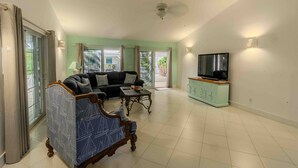 A spacious living room with a sofa, a coffee table, and a television on a cabinet.