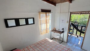 Une chambre à coucher avec un lit, un bureau et une fenêtre avec des rideaux.