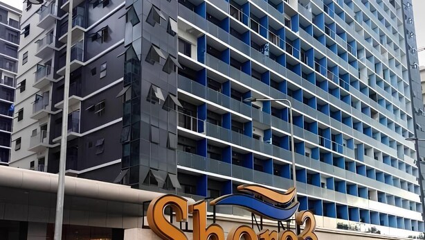 Een modern hotelgebouw met een bord waarop 'Shore3' staat.