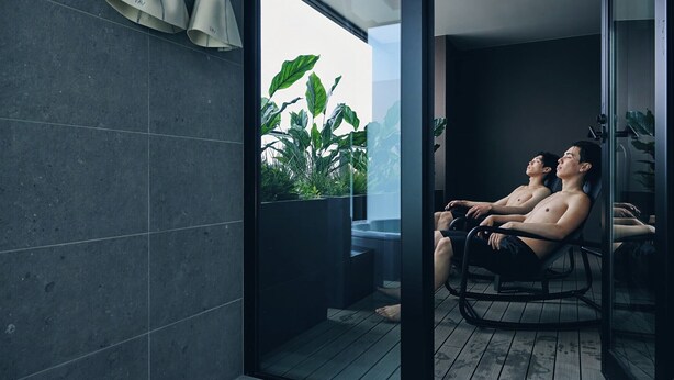 A modern indoor relaxation area with a glass partition, a wooden floor, and a view of greenery outside. - FAV LUX Sapporo Susukino (Sapporo)