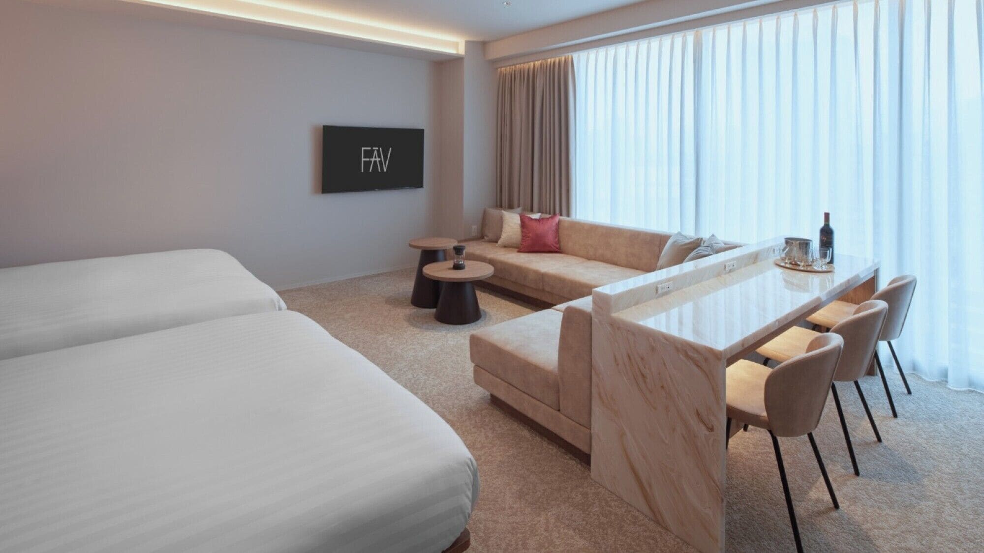 Een moderne hotelkamer met twee eenpersoonsbedden, een sofa, een eettafel met stoelen en een televisie aan de muur.