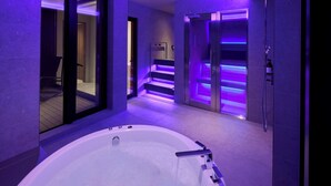 A modern bathroom with a large bathtub, a shower area, and a glass-enclosed staircase. - FAV LUX Sapporo Susukino (Sapporo)