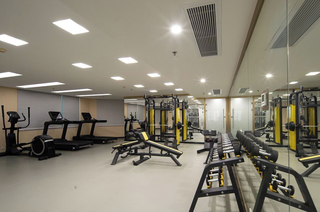 A gym with treadmills, weight machines, and free weights.