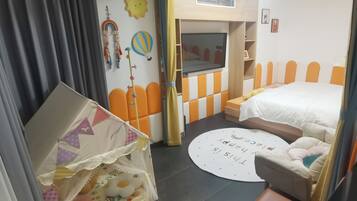 Een kinderkamer met een bed, een speelhoek en een rond vloerkleed met tekst.